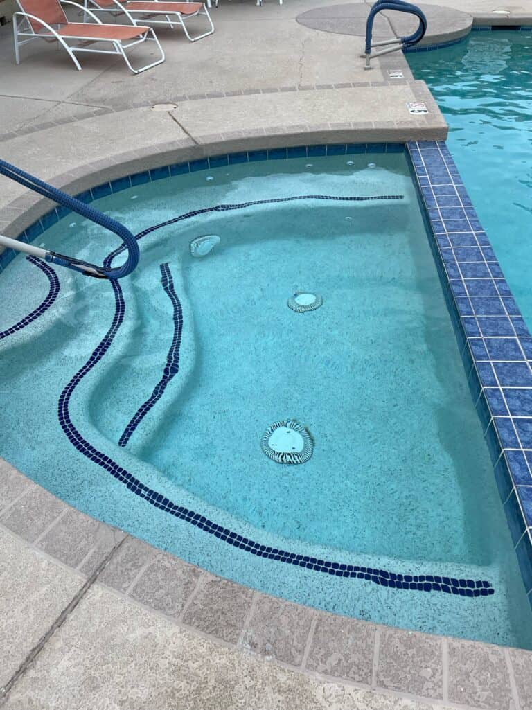 A pool with a hot tub in the backyard.